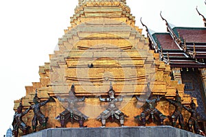 Detail of the golden chedi with the supporting giants around the base, , Wat Phra Kaew, Bangkok, Thailand photo