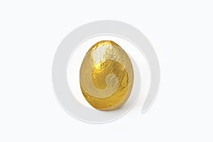 One golden egg  in crinkled metallic gold foil isolated on white background. Easter concept in minimal style