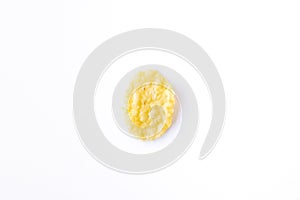 One golden textured sweet corn flake isolated on white background top view