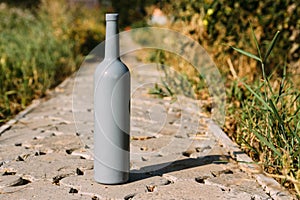 One gray bottle on the road from the tiles, the village, rural alcoholism, drunkenness. alcoholic illness. wine natural drink.