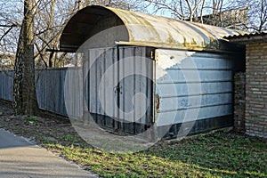 One gray closed metal garage stands outside