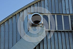 One gray metal industrial pipe fan in the window