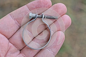one gray metal yoke ring with an iron screw lies in the palm