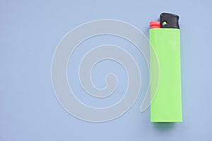 One green lighter on a blue table