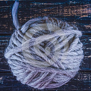 One grey yarn ball on wood background