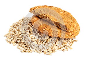 One and half crunchy oat and wholemeal biscuits on a heap of oats isolated on white