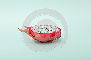 One half of dragon fruit or pitaya on green background