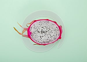 One half of dragon fruit or pitaya on green background