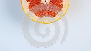 One half of a grapefruit rotates, close up. space for text. The concept of a healthy lifestyle.