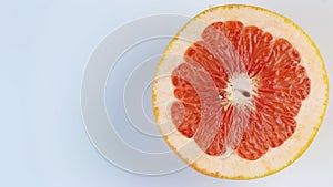One half of a grapefruit rotates, close up. Space for text. The concept of a healthy lifestyle.