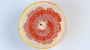 One half of a grapefruit rotates, close up. Space for text. The concept of a healthy lifestyle.