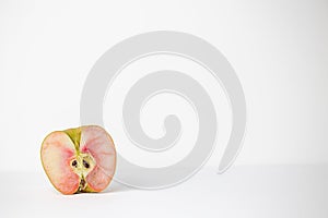 One half of a single lucy glo apple on a white background