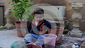 One and a half years old baby boy playing with dirt