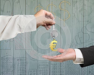 One hand giving key Euro sign keyring to another hand