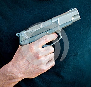 One hand holding a 9 millimeter handgun