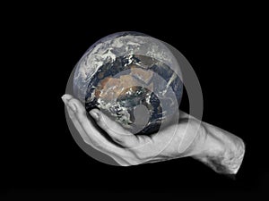 One hand holding planet Earth isolated on black.