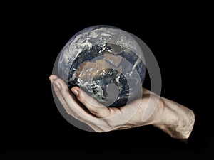 One hand holding planet Earth isolated on black. Elements of this image furnished by NASA.