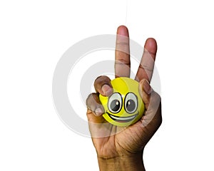 One hand holding a smiling emoji ball in victory sign