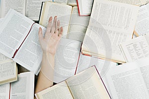 One hand among a lot of books.