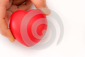 One hand offers a red heart shape