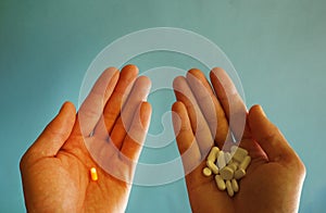 In one hand one bright pill in another many in shadow. concept of effective medicine