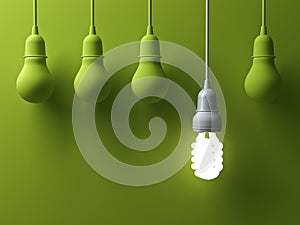 One hanging energy saving light bulb glowing different stand out from unlit incandescent lightbulbs