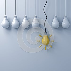 One hanging yellow idea bulb standing out from the dim unlit light bulbs on white wall background