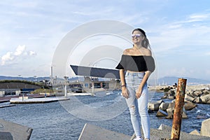 One happy beautiful woman with long hair standing on promenade while looking camera