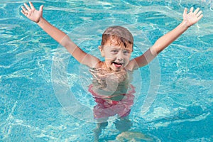 One happy child playing on the swimming pool at the day time.