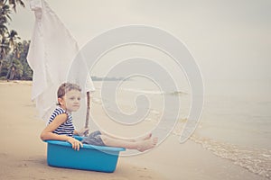 One happy little boy playing on the beach at the day time