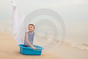 One happy little boy playing on the beach at the day time