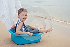 One happy little boy playing on the beach at the day time