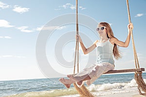 One happy little girl playing on the beach at the day time.