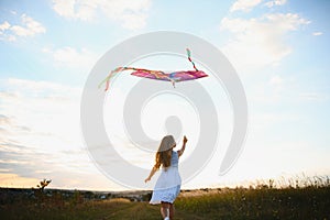 one happy little girl running on field with kite.