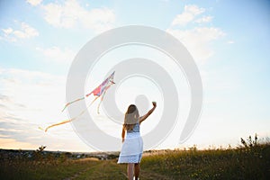 one happy little girl running on field with kite.