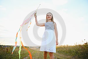 one happy little girl running on field with kite.