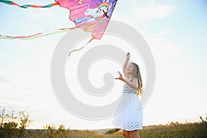 one happy little girl running on field with kite.