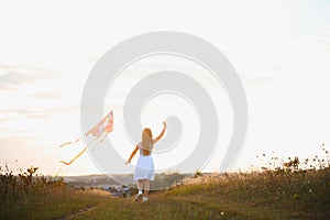 one happy little girl running on field with kite.