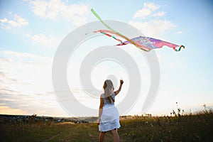 one happy little girl running on field with kite.