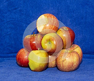 A one has a bite out of it of Apples on Blue Background.