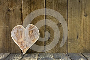 One heart of wood on a old rustic background for a greeting card.