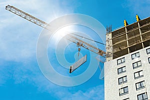 One high-rise with glare crane hauling plate against a house