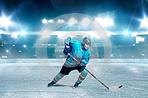 One hockey player skating with stick on ice arena