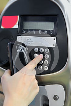 One human hand pressing key on phone