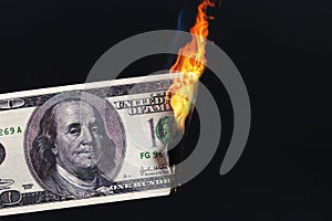 one hundred American dollar burning in fire flame. collapse of dollar. Devaluation. Falling currency