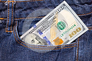 One hundred American dollars bill in pocket of blue jeans