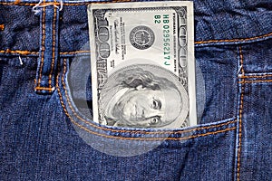 One hundred American dollars bill in pocket of blue jeans