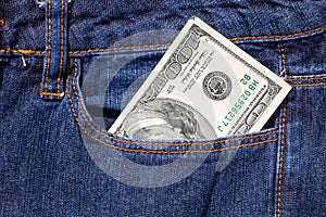 One hundred American dollars bill in a pocket of blue jeans