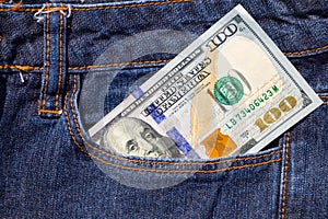 One hundred American dollars bill in pocket of blue jeans