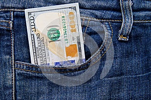 One hundred American dollars bill in pocket of blue jeans